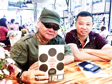 Tác giả Lữ Đắc Long (bên phải) tặng sách cho bạn bè. (Ảnh do nhân vật cung cấp)