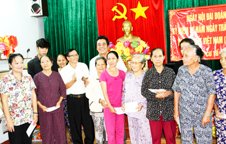 Đồng chí Lê Thanh Quang (đứng giữa, hàng phía sau) chụp ảnh cùng các hộ có hoàn cảnh khó khăn ở Tổ 10 Hòa Bắc