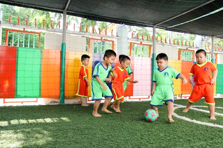 Các bé đá bóng tại sân bóng mini của trường
