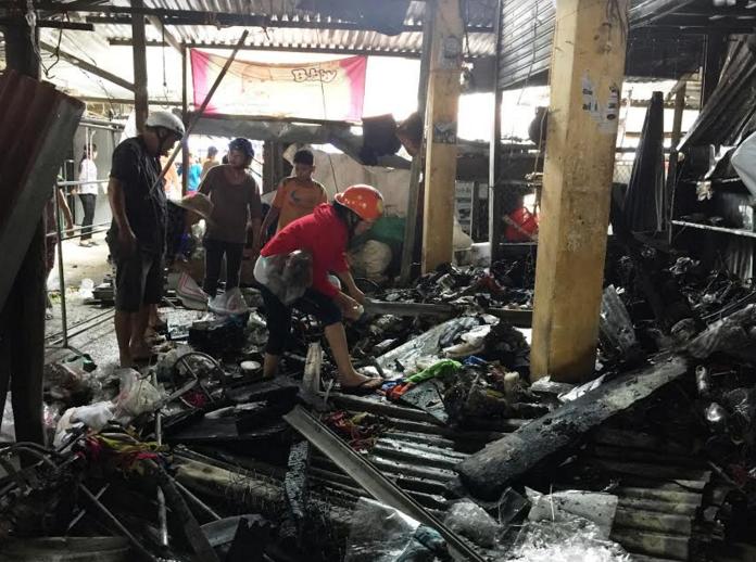 Tiểu thương cố nhặt nhạnh những gì còn sót lại trong đống tro tàn.