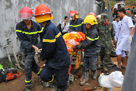 Lực lượng chức năng đưa thi thể anh Sang ra khỏi đống đổ nát.