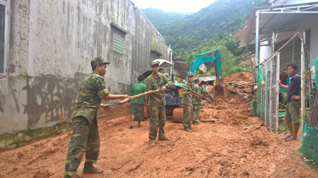 Các bộ, chiến sĩ thuộc các đơn vị hỗ trợ người dân di chuyển tài sản tại những ngôi nhà bị sập một phần ra nơi an toàn.