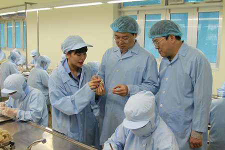 Ông Lê Quốc Phong (giữa) và ông Nguyễn Duy Bắc nghe giới thiệu về sản phẩm yến sào.