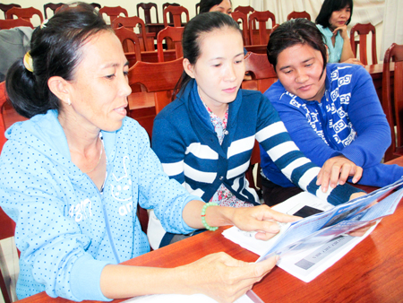 Chị Nga (bên trái) trao đổi kinh nghiệm tuyên truyền dân số với các cộng tác viên khác