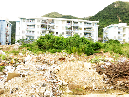 Bãi đất trống trước mặt Chung cư Bình Phú đầy xà bần và rác