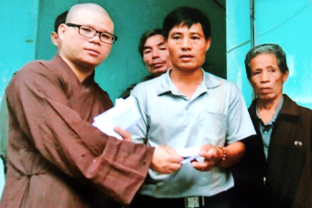 Đại diện Ban từ thiện xã hội Phật giáo tỉnh trao hỗ trợ cho các gia đình bị ảnh hưởng do sạt lở núi ở Phước Đồng.