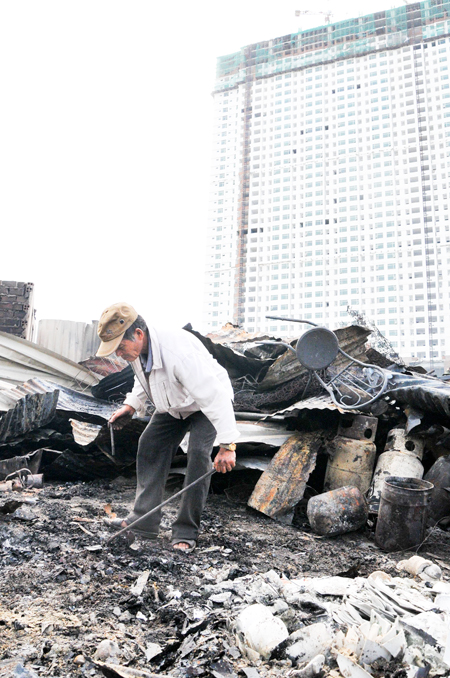 Một người dân cố gắng nhặt nhạnh những gì còn sót lại của gia đình