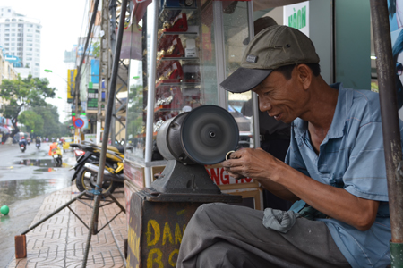 A man polishing copper items on Thong Nhat Street.