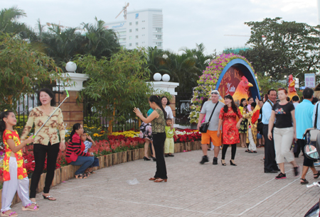 People taking souvenir photos with Tet decorations.