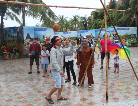 Tourists playing a folk game which is beating clay pots while being blindfolded.