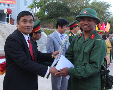 Ông Mấu Thái Cư - Bí thư huyện ủy Khánh Sơn tặng hoa cho các thanh niên địa phương lên đường nhập ngũ.