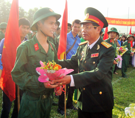 Đại tá Trần Thân - Phó Chính ủy Bộ Chỉ huy Quân sự tỉnh Khánh Hòa tặng hoa động viên các tân binh.