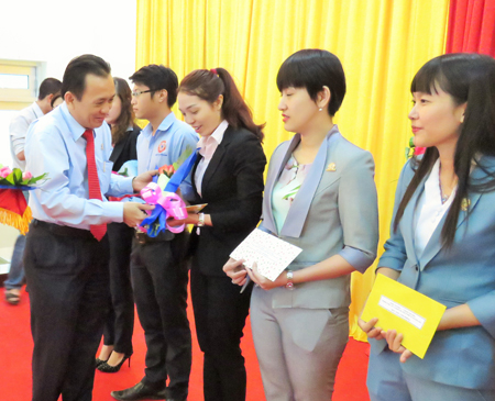Le Huu Hoang, Chairman of Members’ Council of Khanh Hoa Salanganes Nest Company, giving flowers to company’s outstanding staffs.