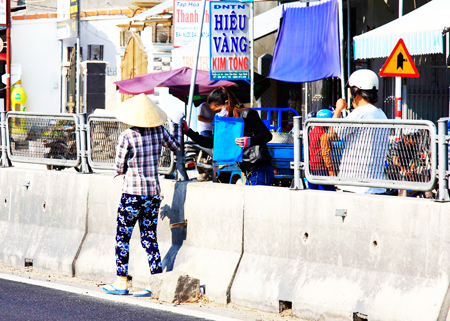 Người dân băng qua dải phân cách trên tuyến Quốc lộ 1 đoạn qua huyện Vạn Ninh