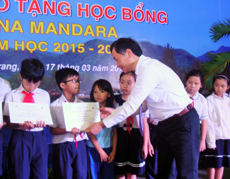Ông Nguyễn Đắc Tài trao học bổng cho các học sinh.