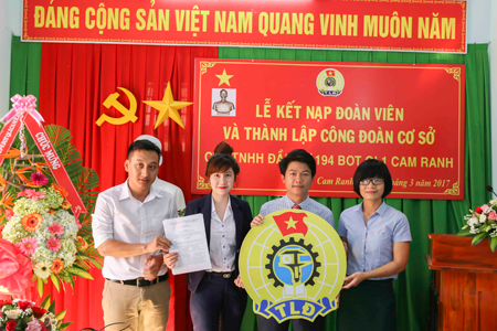 Đại diện Liên đoàn Lao động TP. Cam Ranh (bìa phải) trao quyết định và logo của ngành cho Công đoàn Công ty TNHH Đầu tư BOT Quốc lộ 1 Cam Ranh