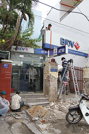 Nhân viên chi nhánh ngân hàng tự tháo dỡ phần hành lang lấn chiếm vỉa hè.