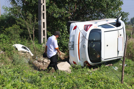 Tông vào cọc bê tông, taxi lật ngang