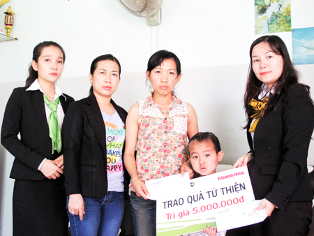 Đại diện Báo Khánh Hòa và Vietcombank Nha Trang trao tiền ủng hộ cho gia đình cháu Nguyễn Minh Huy