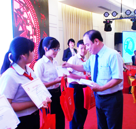 Ông Võ Bình Tân - Phó Giám đốc Sở Lao động - Thương binh và Xã hội trao học bổng cho học sinh