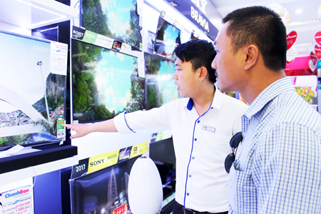 Nhân viên một hãng điện máy giới thiệu cho khách hàng về thông tin của nhãn năng lượng