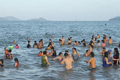Người dân và du khách hòa mình trong làn nước biển.