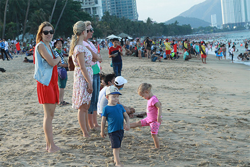 Du khách nước ngoài hóng gió trên bãi biển Nha Trang.