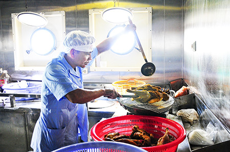 Thành viên tổ phục vụ trên tàu Khánh Hòa 01 chuẩn bị bữa ăn  cho đoàn công tác