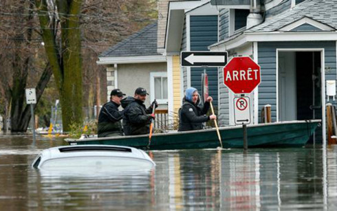 Người dân ở Getineau, Quebec, Canada, chèo thuyền vì nước dâng cao. Ảnh: Reuters