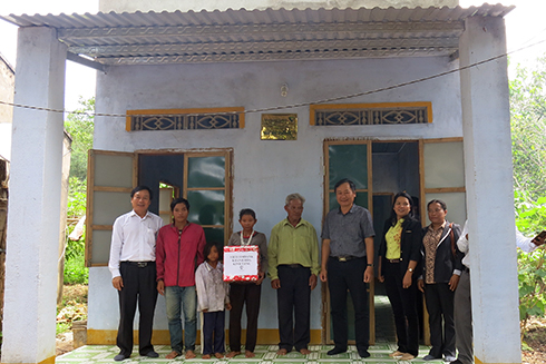 Ông Nguyễn Đắc Tài (thứ ba từ phải sang) và ông Lương Phan Sảng (bìa trái) - Giám đốc Vietcombank Khánh Hòa tặng quà cho hộ anh Cao Ký. 