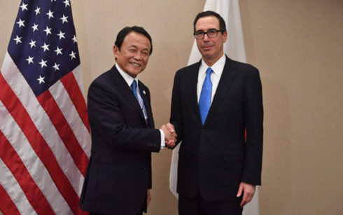 Bộ trưởng Tài chính Nhật Bản Taro Aso (trái) và người đồng cấp Mỹ Steven Mnuchin (phải) bắt tay nhau trong một cuộc gặp tại Washington. Ảnh: AFP.