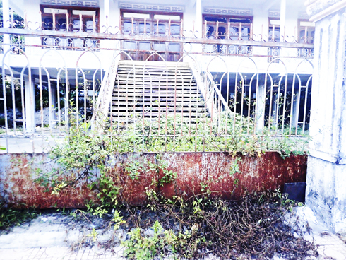 Cỏ mọc lấp cổng nhà cộng đồng