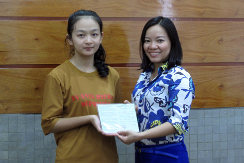 Thai Thi Le Hang, Deputy Editor-in-Chief of Khanh Hoa Newspaper giving passbook to Hang Thi Minh Thu.