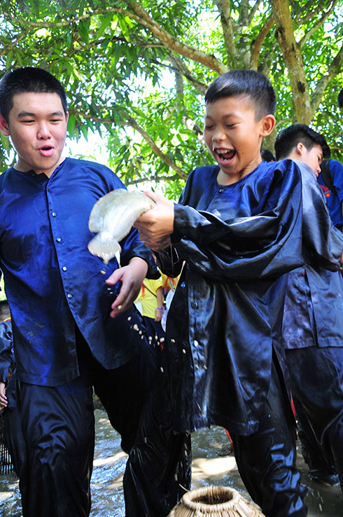 Hai thiếu nhi Lào thích thú khi bắt được cá