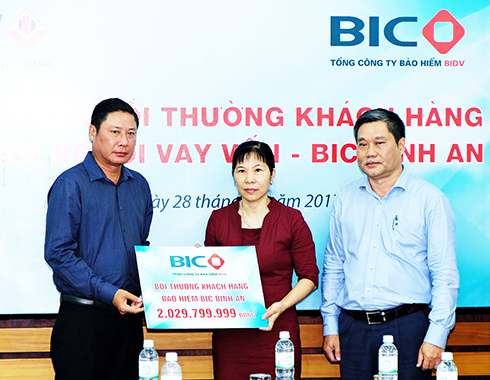 Đại diện lãnh đạo Tổng Công ty BIC và Ngân hàng BIDV Chi nhánh Khánh Hòa trao số tiền bồi thường cho đại diện gia đình khách hàng