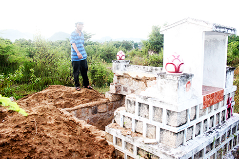 Ông Văn Minh Chánh bên những phần mộ đã bị ông Võ Trần Cảnh đào đưa đi chôn cất nơi khác