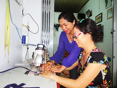 Chị Thành (bên trái) hướng dẫn hội viên phụ nữ gia công giày dép tại nhà
