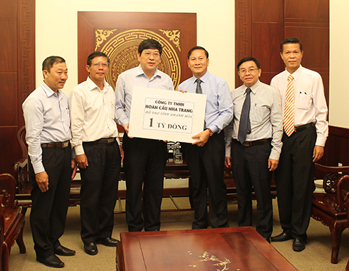 Đồng chí Nguyễn Duy Bắc (bên trái) tiếp nhận 1 tỷ đồng ủng hộ của Công ty TNHH Hoàn Cầu Nha Trang.