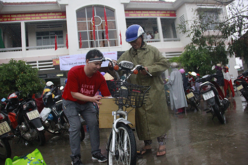 Ông Đoàn Diệp Bình - Trưởng phòng Truyền thông và sự kiện LOTTE Mart Việt Nam hỗ trợ người dân đưa quà về nhà