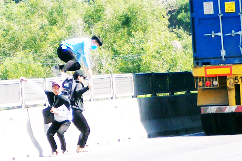 Học sinh nhảy qua dải phân cách