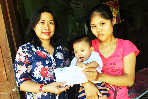 Đại diện Báo Khánh Hòa trao tiền ủng hộ của bạn đọc cho gia đình bé Lê Thị Kim Sang
