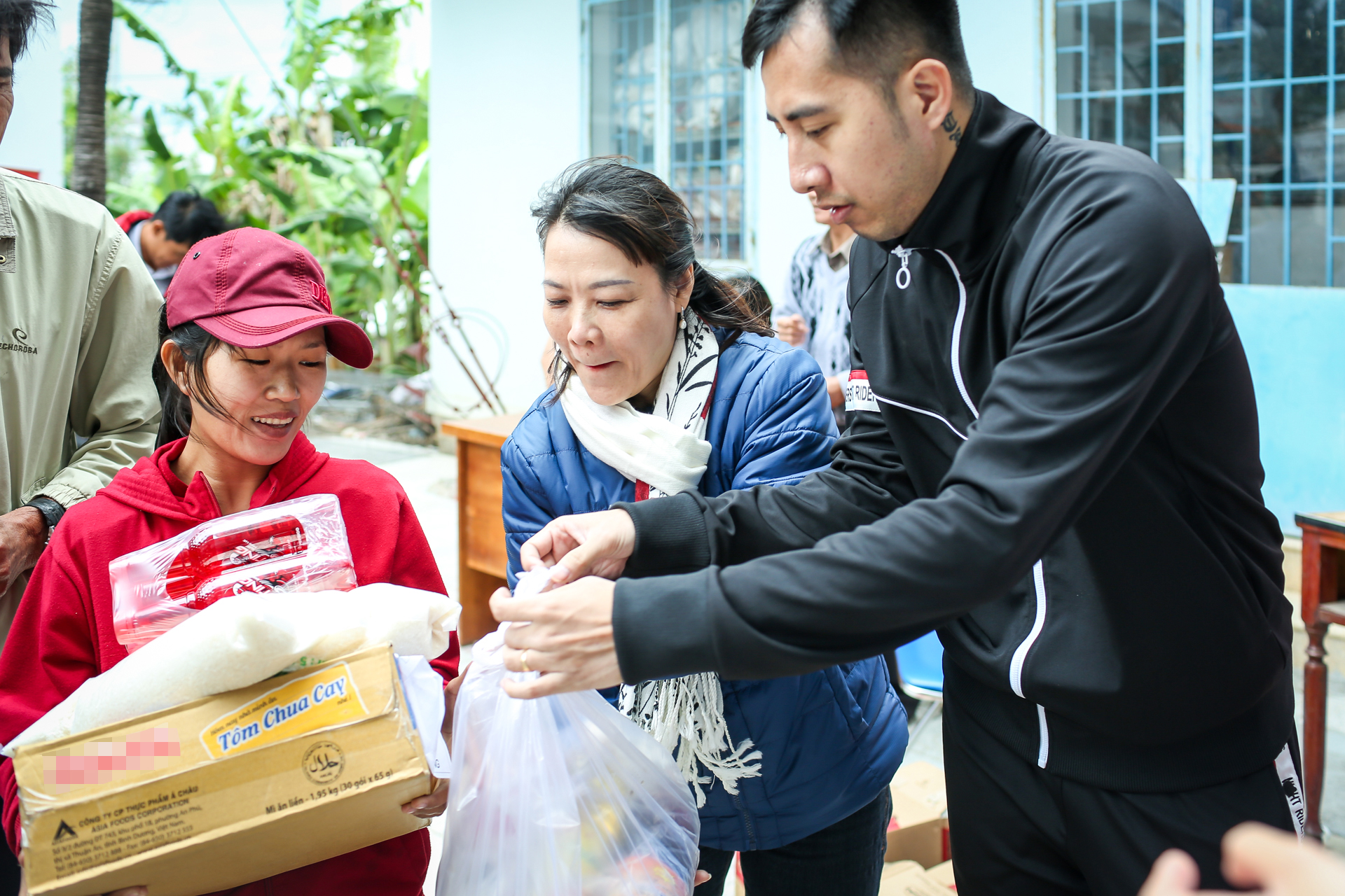Bà Trương Thị Thu Thảo, Phó chủ tịch Uỷ ban Mặt trận tổ quốc Việt Nam TP. Nha Trang (giữa) trao quà cho bà con tại xã Vĩnh Lương. 