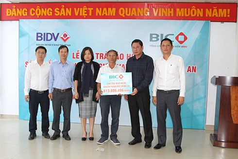 Lãnh đạo BIC và đại diện Ngân hàng BIDV Chi nhánh Nha Trang trao tiền bồi thường cho gia đình khách hàng