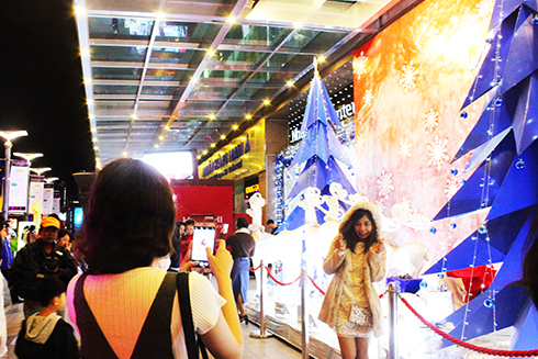 Người dân và du khách chụp ảnh kỷ niệm tại khu vực trang trí Noel của một trung tâm thương mại