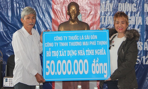 Đại diện Công ty TNHH Thương mại Phú Thịnh (bên phải) trao kinh phí hỗ trợ xây nhà cho gia đình ông Đỗ Văn Ninh.