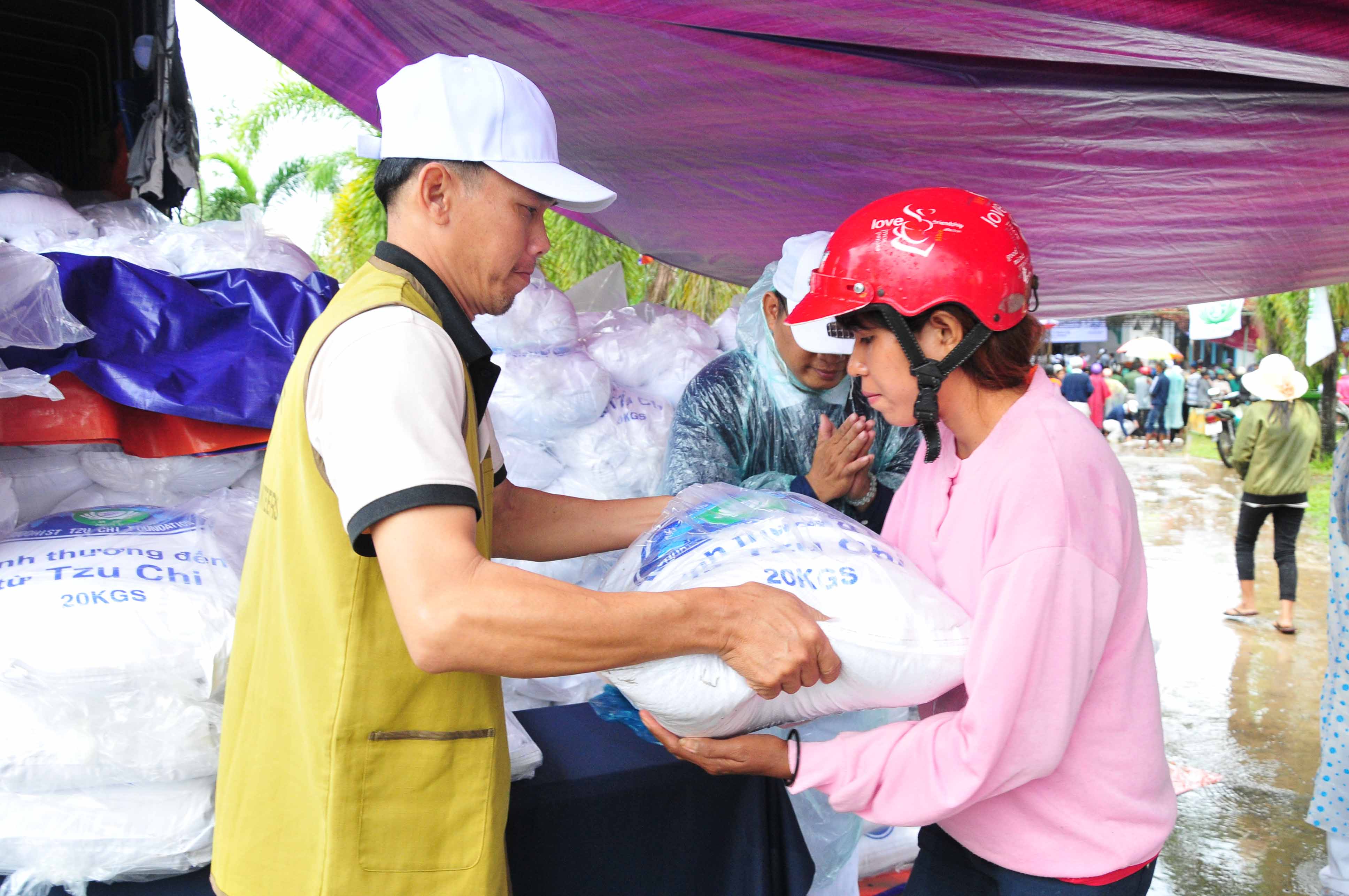 Các tình nguyện viên trao gạo cho người dân