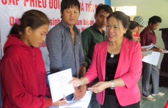 Bà Nguyễn Thị Xuân Thu trao phiếu mua hàng cho người dân