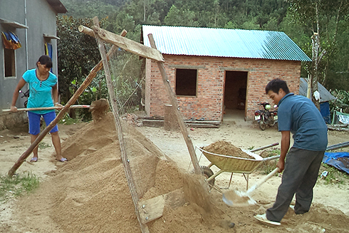 Gia đình bà Cao Thị Minh Lệ đang thi công những phần việc cuối cùng của căn nhà mới. Ảnh: Quốc Nguyên