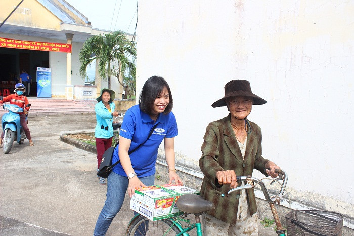 Nhân viên Công ty Nha Trang Ford giúp người dân đưa quà về nhà. 