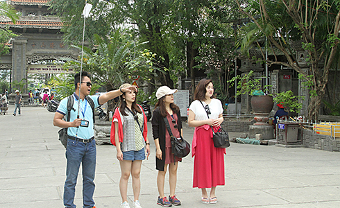 Thành viên của nhóm hướng dẫn viên du lịch tiếng Nhật dẫn khách tham quan chùa Long Sơn.